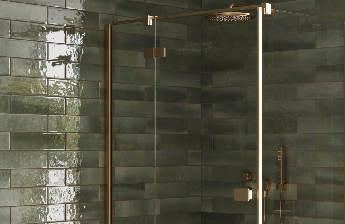 Glossy olive green shower wall tiles in a modern glass-enclosed shower, paired with brushed brass fixtures for a warm, contemporary look