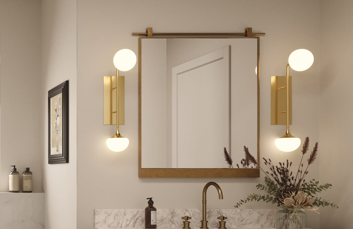 Elegant bathroom with a gold-framed square mirror centered above a marble vanity and soft ambient lighting.