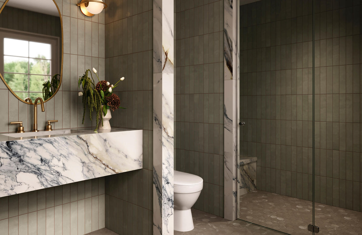 Spa-inspired bathroom with green Moroccan vertical tiles, marble vanity, brass fixtures, and a glass-enclosed shower for a calm, refined look.