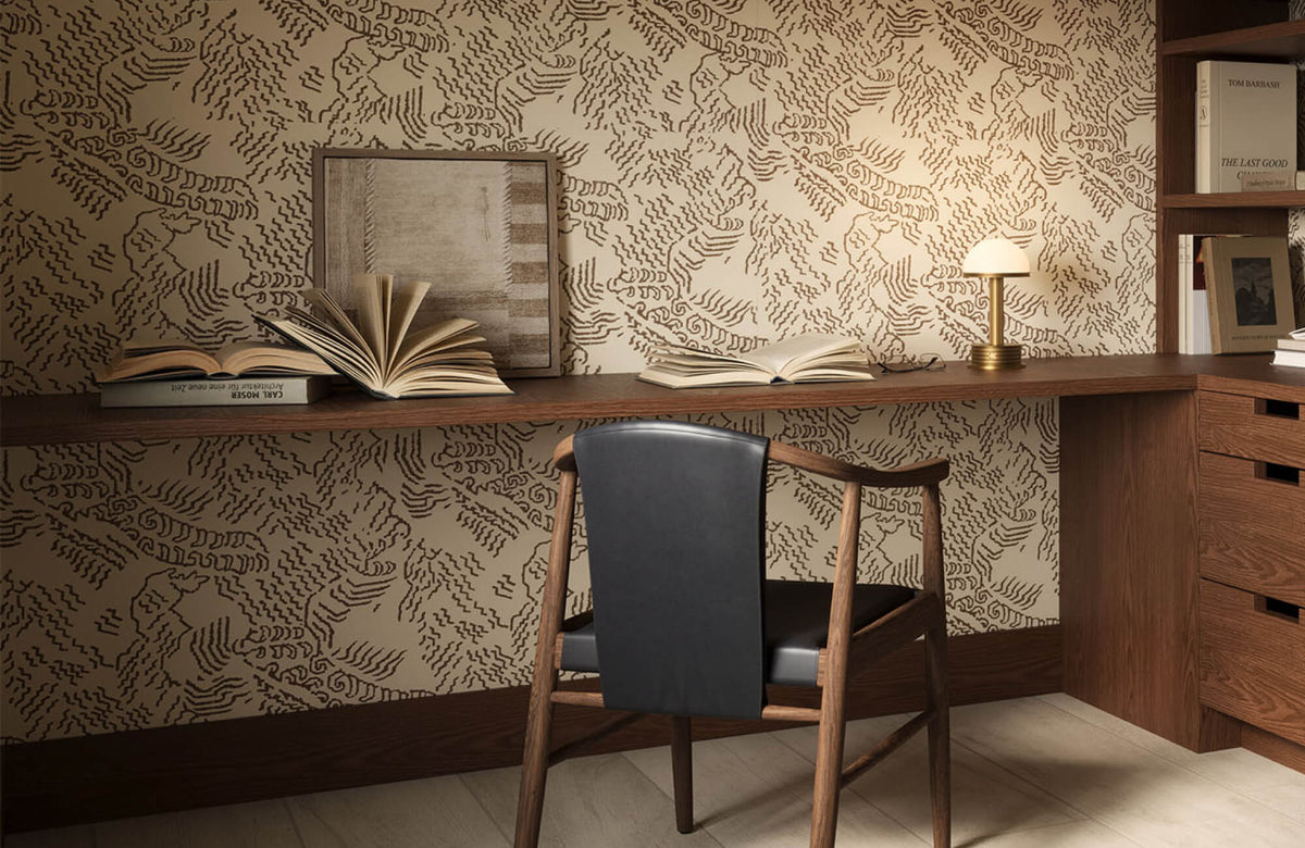 Contemporary home office with a wood desk and chair, patterned wall art, open shelving, books, and a desk lamp.