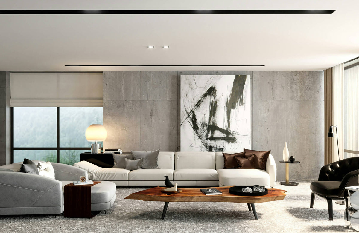 Modern living room with curved sofa, decorative pillows, wood coffee table, wall art, and large concrete wall panels.