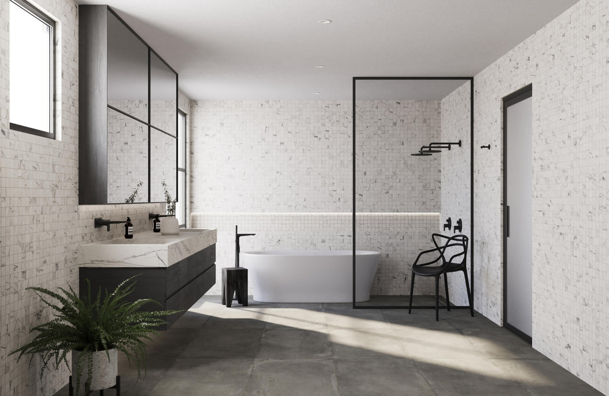 Modern bathroom with a white freestanding bathtub on a large square format dark gray tile floor, black fixtures, and walls that feature a textured mosaic tile pattern in white with gray veining.