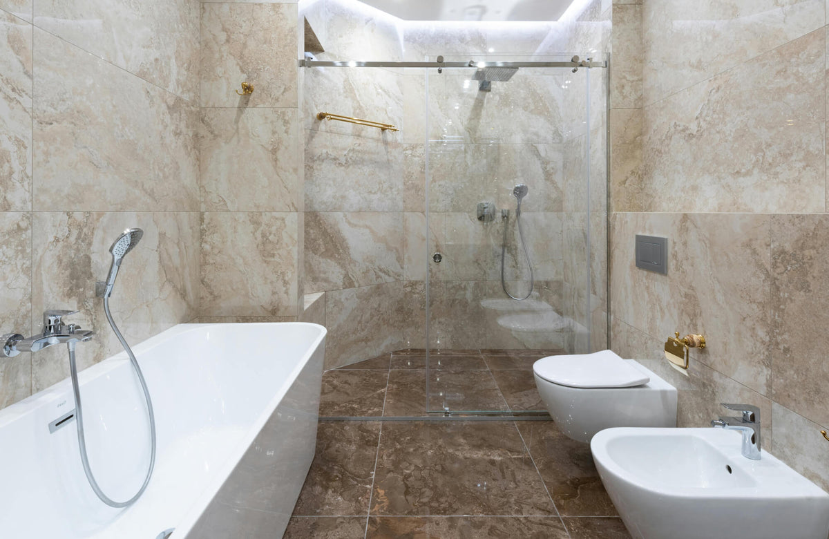 Luxurious bathroom with beige marble tiles, a glass-enclosed shower, and a modern freestanding tub.