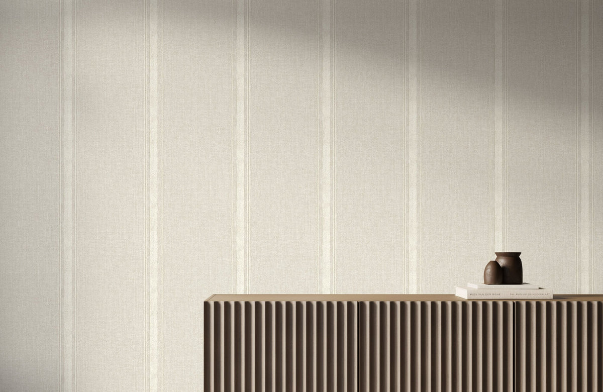 Striped wallpaper in soft ivory tones features subtle vertical bands and a textured linen-like surface, creating a refined backdrop for a modern fluted wood console.