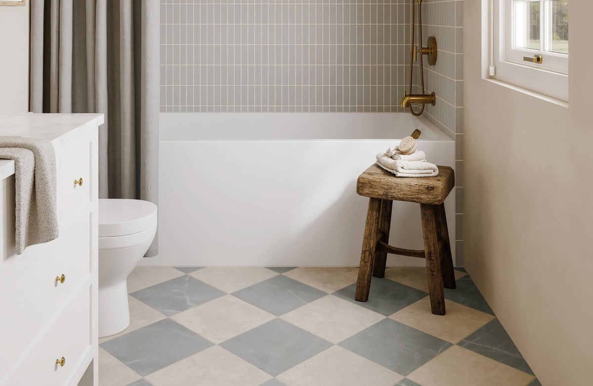 Modern bathroom with soft beige and gray checkerboard floor tiles, wood stool, white tub, and vertical rectangular wall tile backdrop.