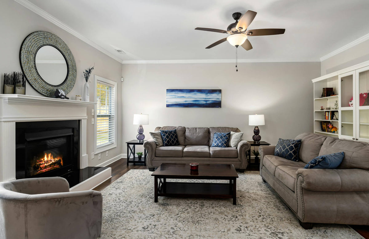 Spacious living room with two sofas styled with different pillow counts, showing how two versus four pillows affect balance and visual weight in a larger seating area.