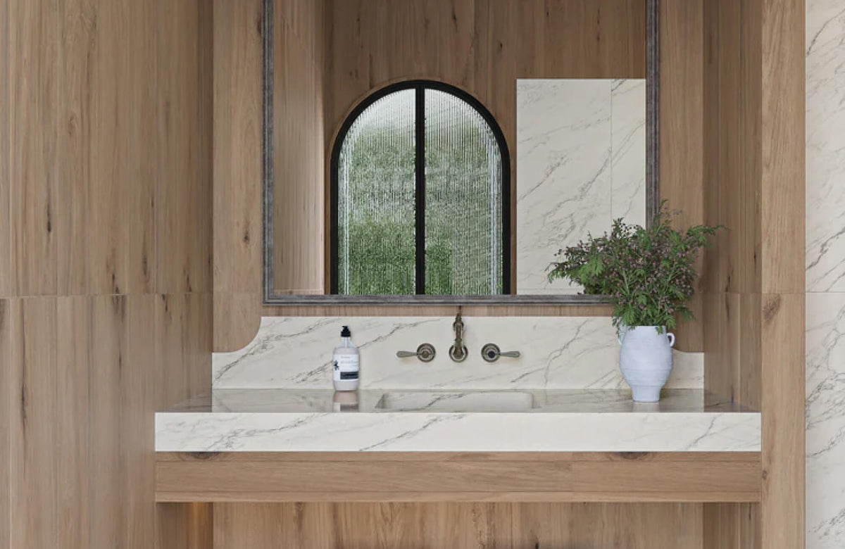 Elegant wood-look wall tiles seamlessly blend with a marble sink backsplash, creating a natural and luxurious bathroom ambiance.