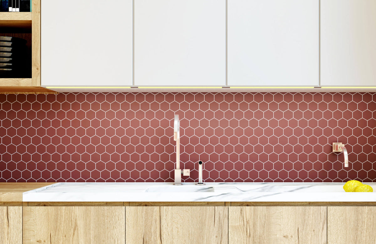 Modern kitchen with a red hexagon tile backsplash, white upper cabinets, wood lower cabinets, and a sleek sink with faucet.