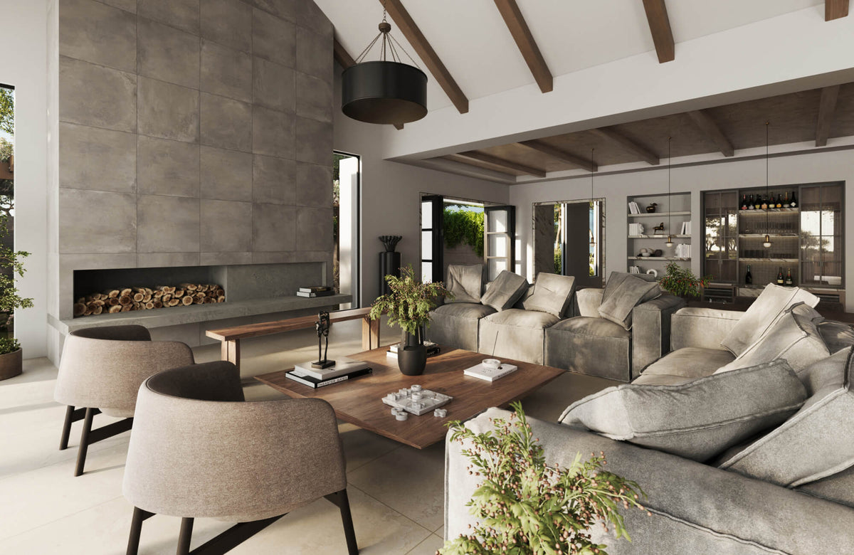 Modern living room with neutral sofa and oversized decorative pillows, wood beams, stone fireplace, and warm natural lighting.