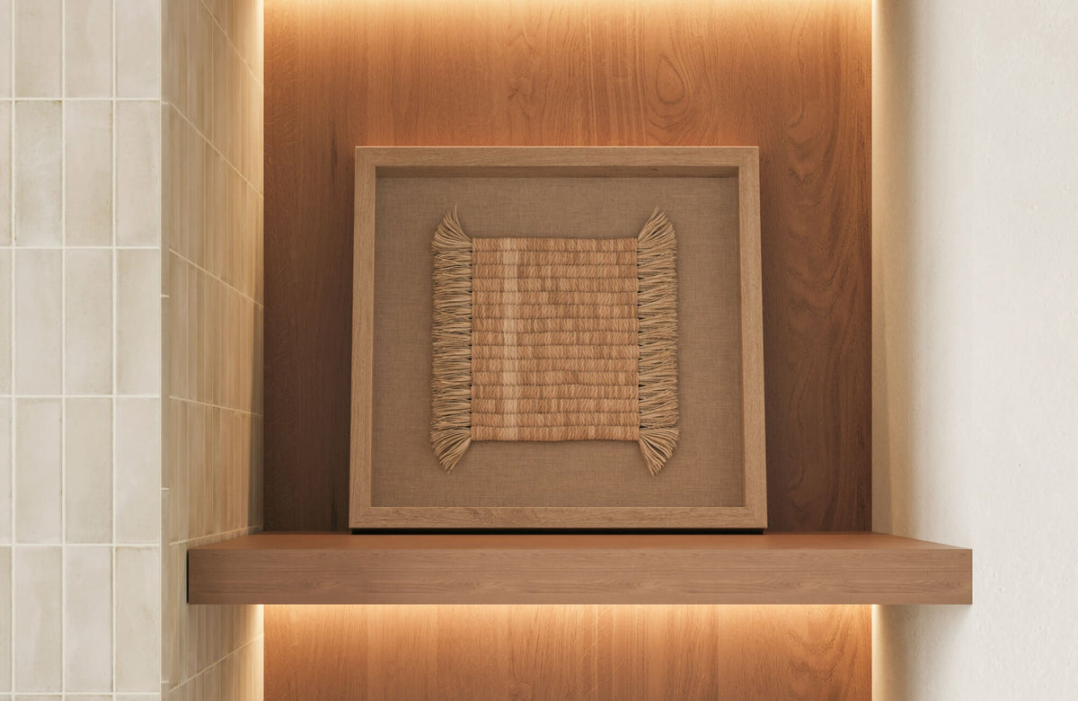 Woven natural fiber wall art in a wood-framed niche with warm backlighting and subway tiled wall detail.