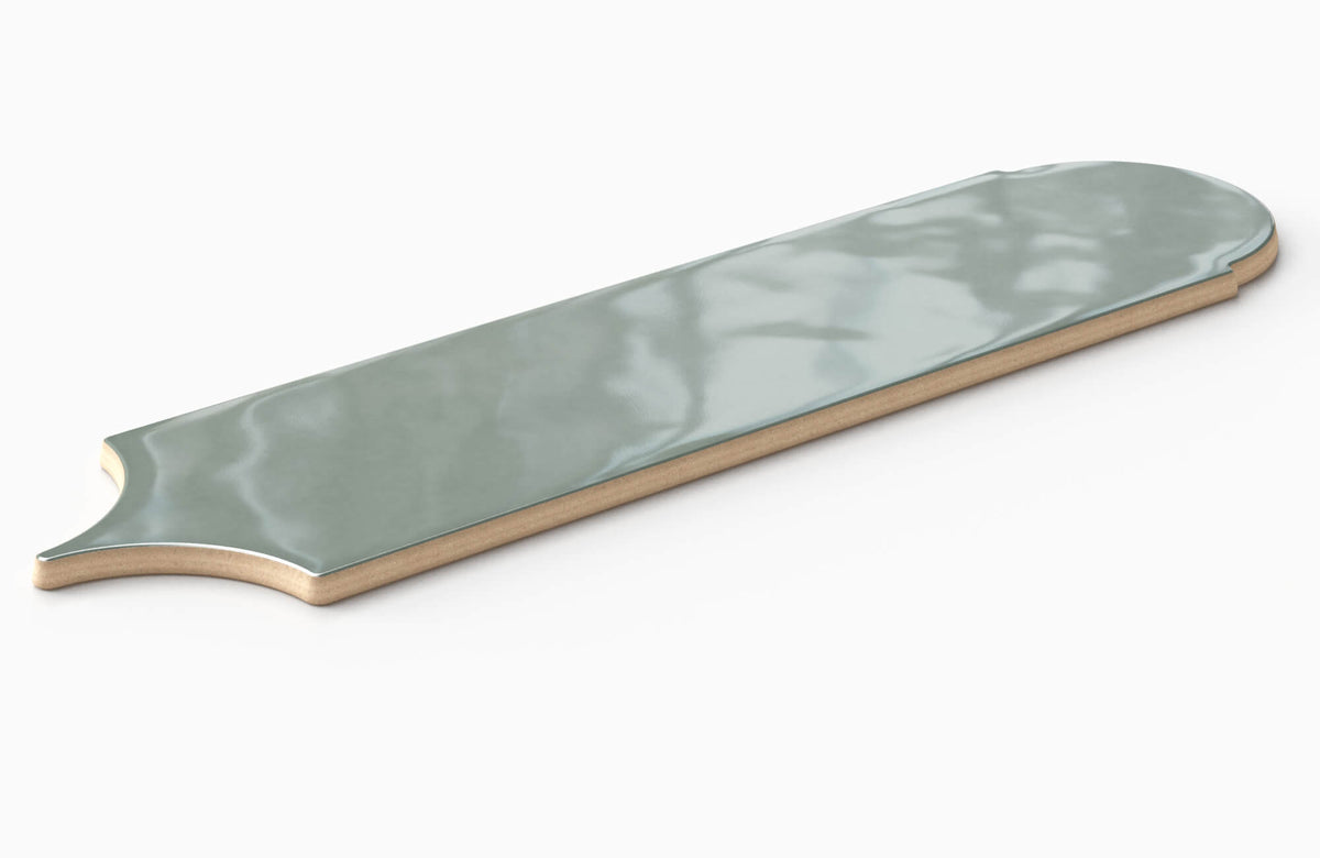 Full tile sample of a glossy sage green ceramic wall tile with elongated decorative shaping and reflective handcrafted variation.