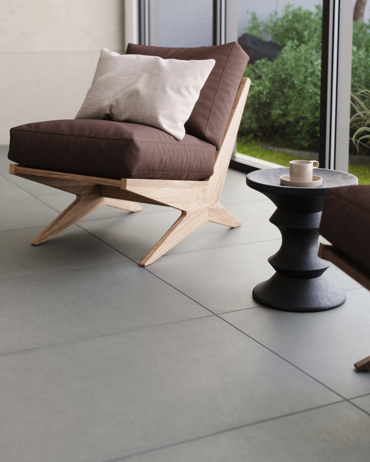 A cozy living space featuring soft grey floor tiles paired with minimalist furniture and a touch of greenery outside.