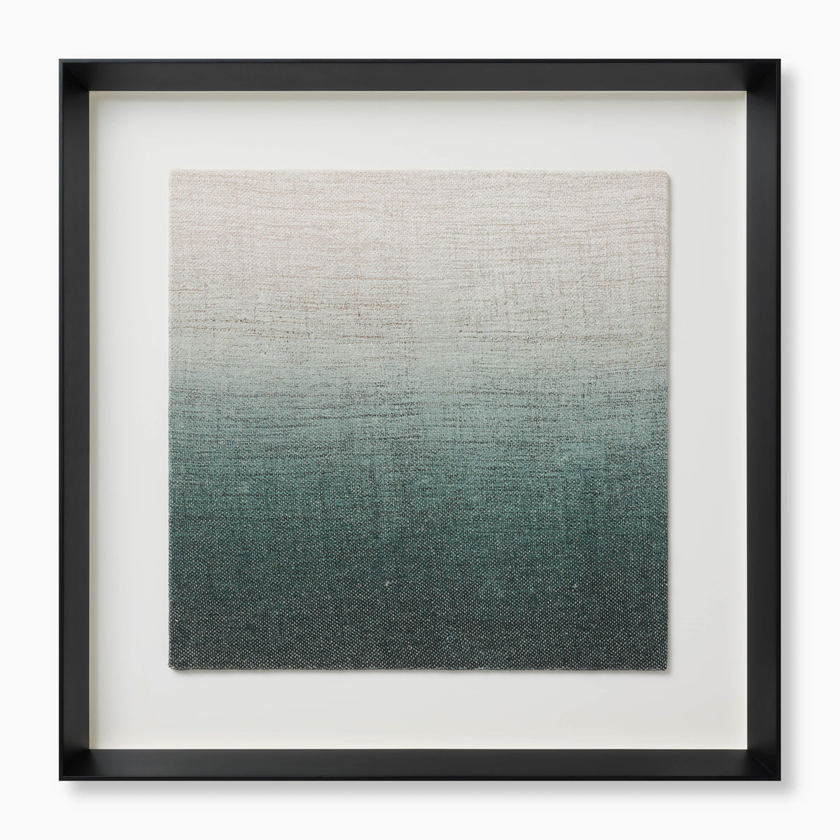 Framed textile artwork with a soft gradient from pale neutral tones into deeper, greenish blue shades, housed in a black shadowbox frame for a modern, tactile accent.