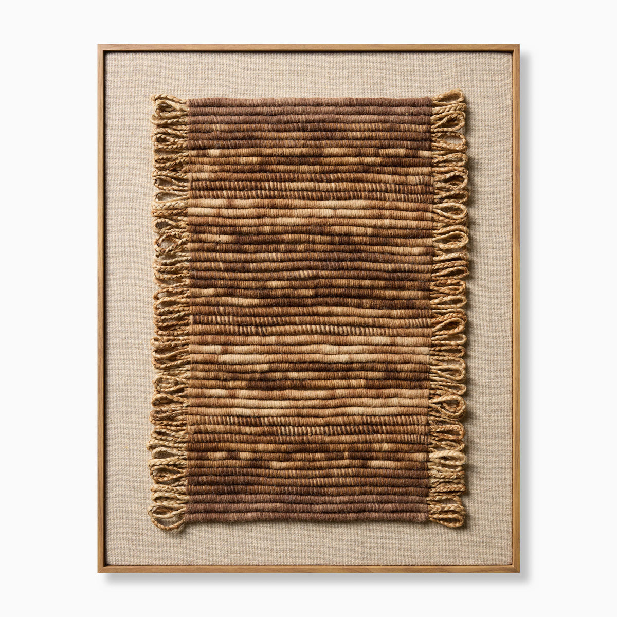 Framed textile wall art featuring a vertically oriented handwoven panel with layered brown and beige fibers, subtle fringe detailing, and a natural wood frame for a warm, organic, artisanal look.