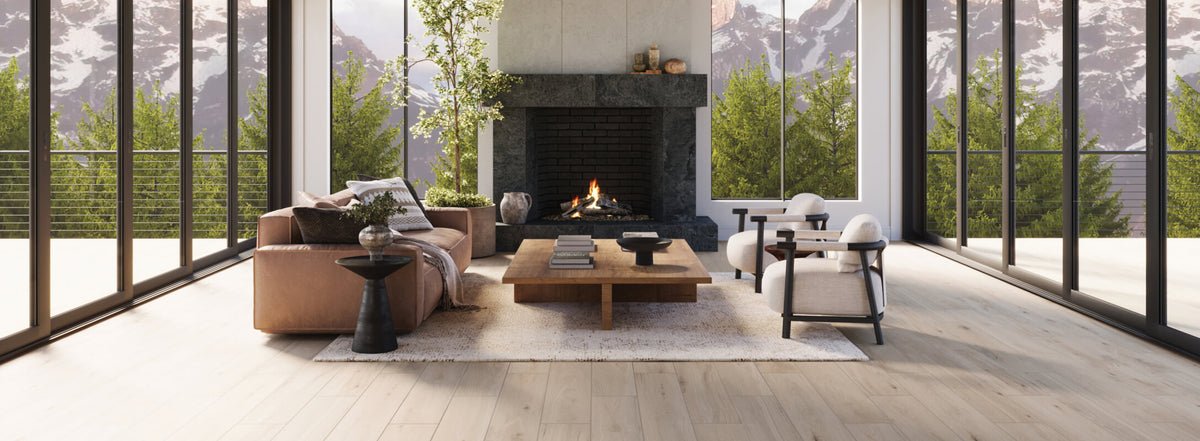 The living room showcases light wood-look floor tiles, paired with dark, stone-look tiles surrounding the fireplace with beige stone-look tiles extending above it, creating a striking contrast. Large windows frame a breathtaking mountain view, enhancing the seamless connection between the indoor and outdoor spaces