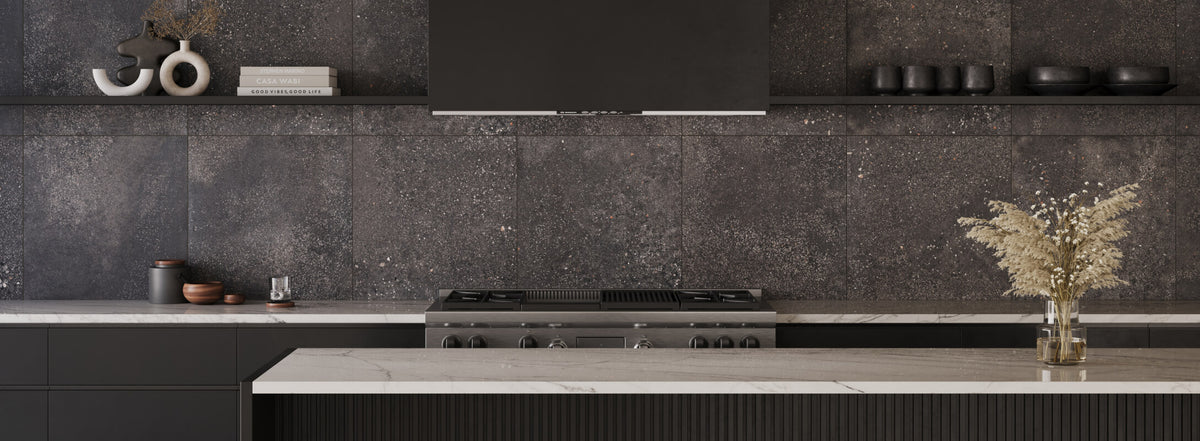 Sleek kitchen with dark, speckled concrete look tiles, minimalistic black cabinetry, and contrasting light countertops, accented with rustic decor elements