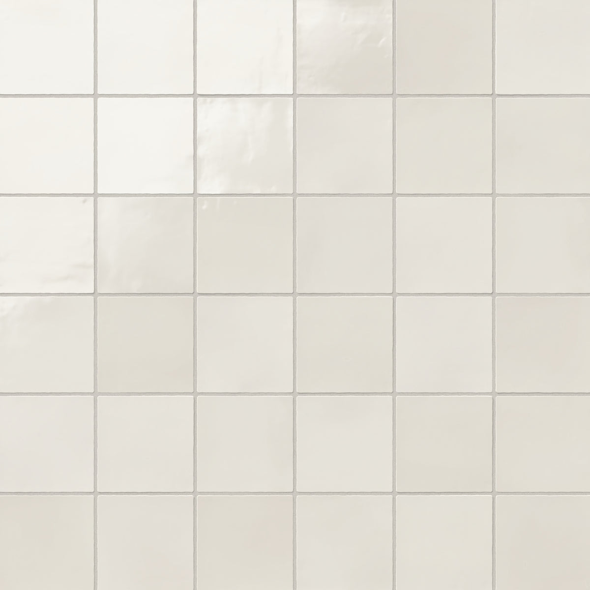 Square 4x4 glossy ceramic tiles in a soft off-white hue with subtle reflections, offering a clean and timeless look for versatile design applications