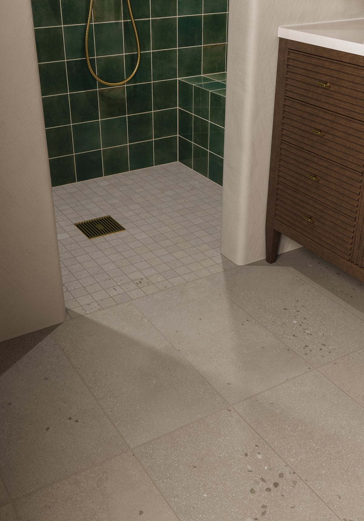 Bathroom floor with light gray tiles leading into a shower lined with rustic dark green porcelain tiles.