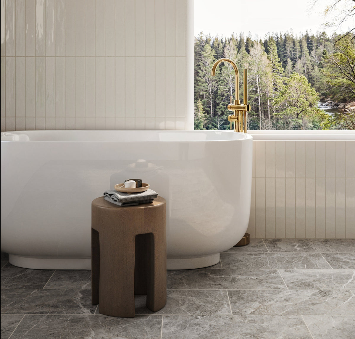 A serene bathroom featuring a freestanding white bathtub with a gold faucet, set against glossy vertical wall tiles and a matte grey veined tile floor.