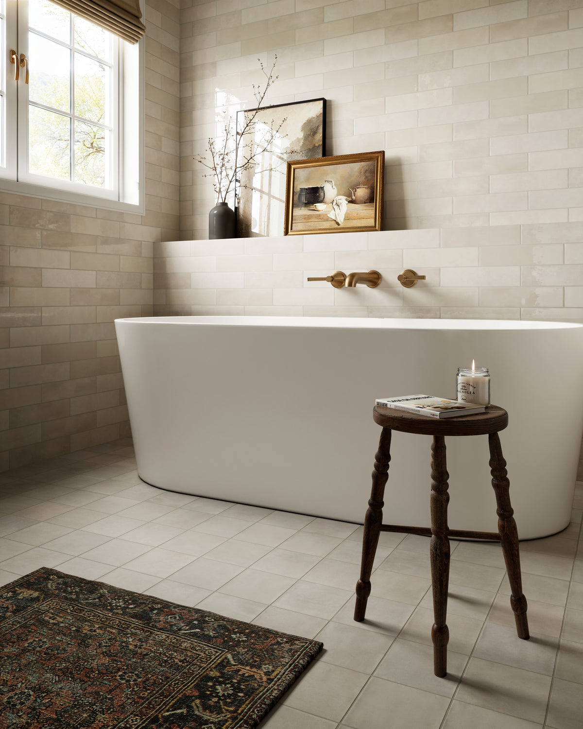 Karina 5.5x5.5 matte porcelain tile in Greige, combining soft taupe and warm grey tones for a handcrafted, monochrome look that adds serene texture to this spa-inspired bathroom with a freestanding tub and curated wall art.