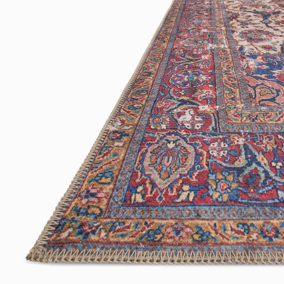 Pascal Polyester Face Rug in Natural / Spice, blending soft cream with rich rust and sapphire blue accents in an ornate, vintage-style pattern.
