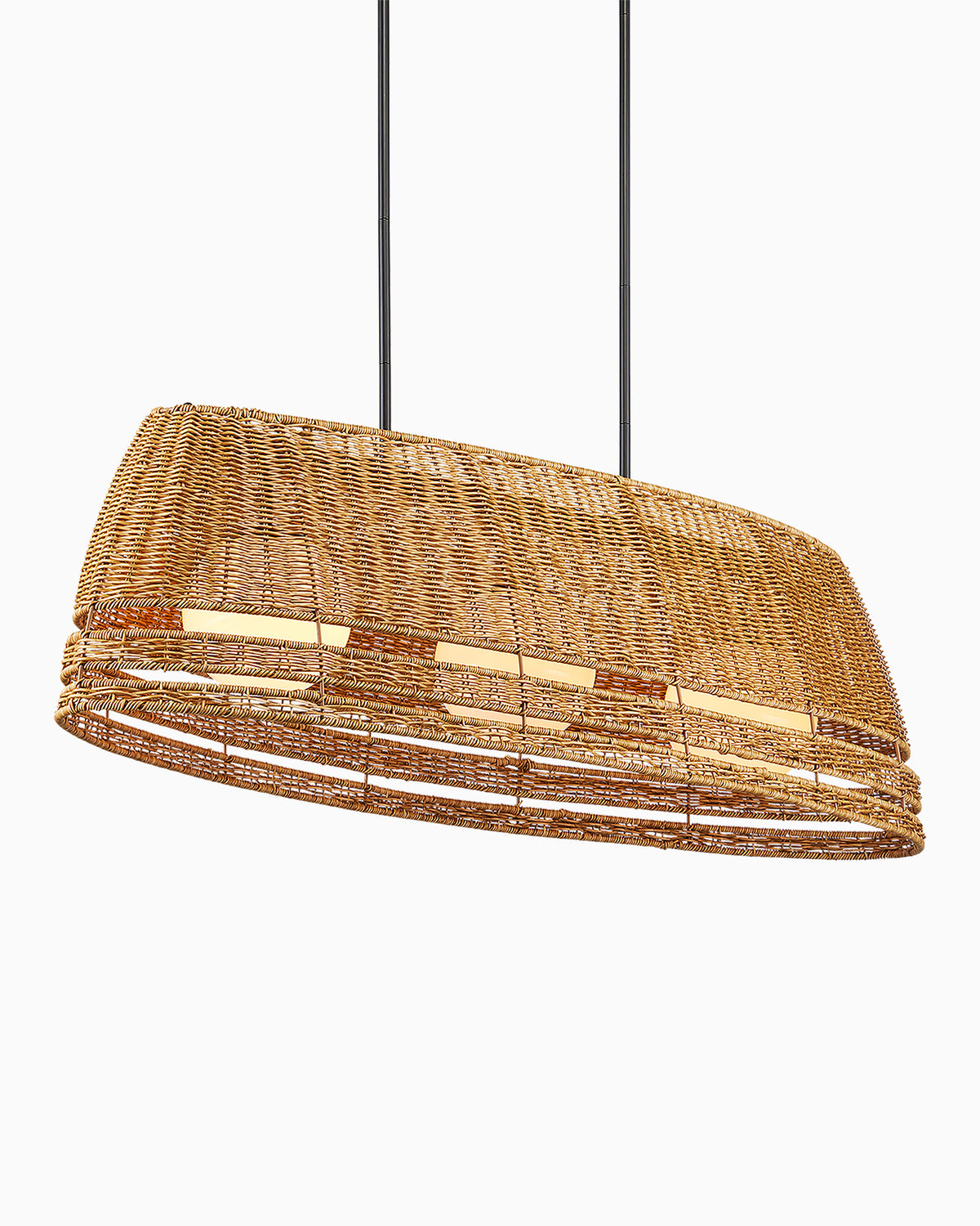 The upturned boat-shaped honey brown wicker frame of our Rivington Oval Outdoor Chandelier houses three warm white milk glass lights, hanging from two sleek black ceiling rods.