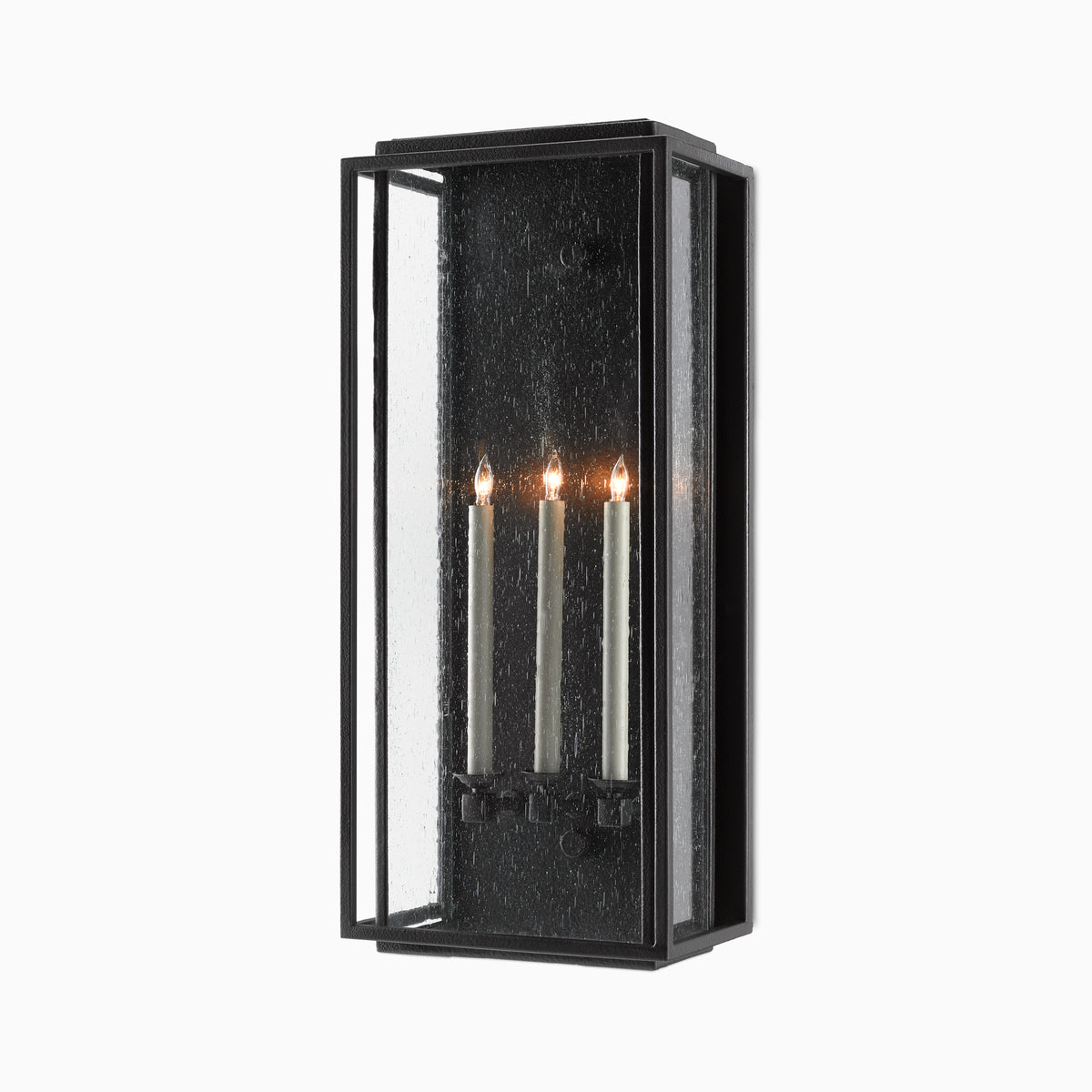 Black rectangular wall sconce with seeded glass panels and three lit candle-style lights on a plain white background.