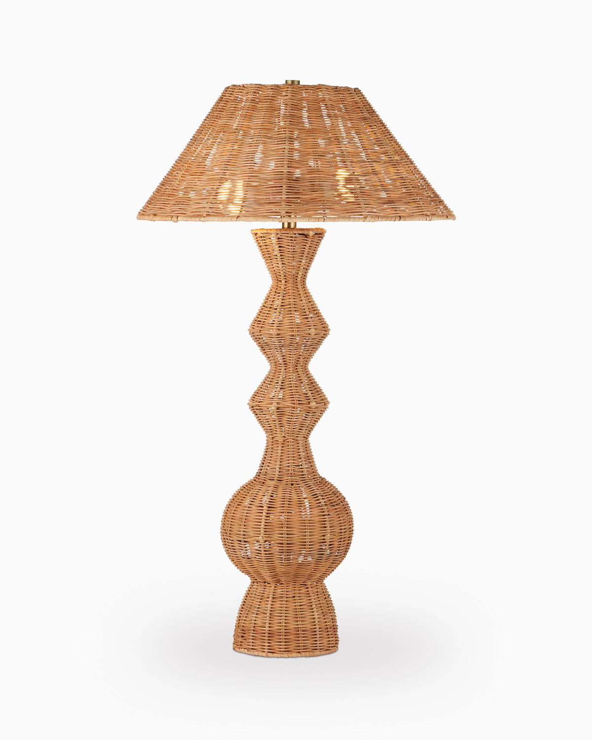 Natural woven rattan table lamp with a square tapered shade and sculptural stacked base on a plain white background.