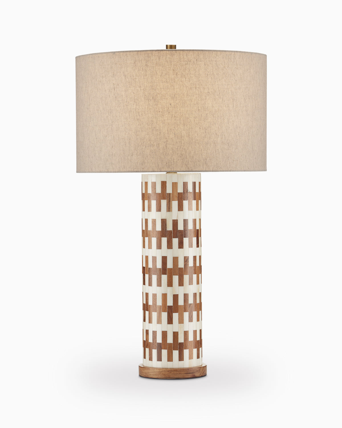 Table lamp with a cylindrical body wrapped in an interlocking off-white and brown block pattern, set on a simple wood base with a natural linen drum shade and golden finial.