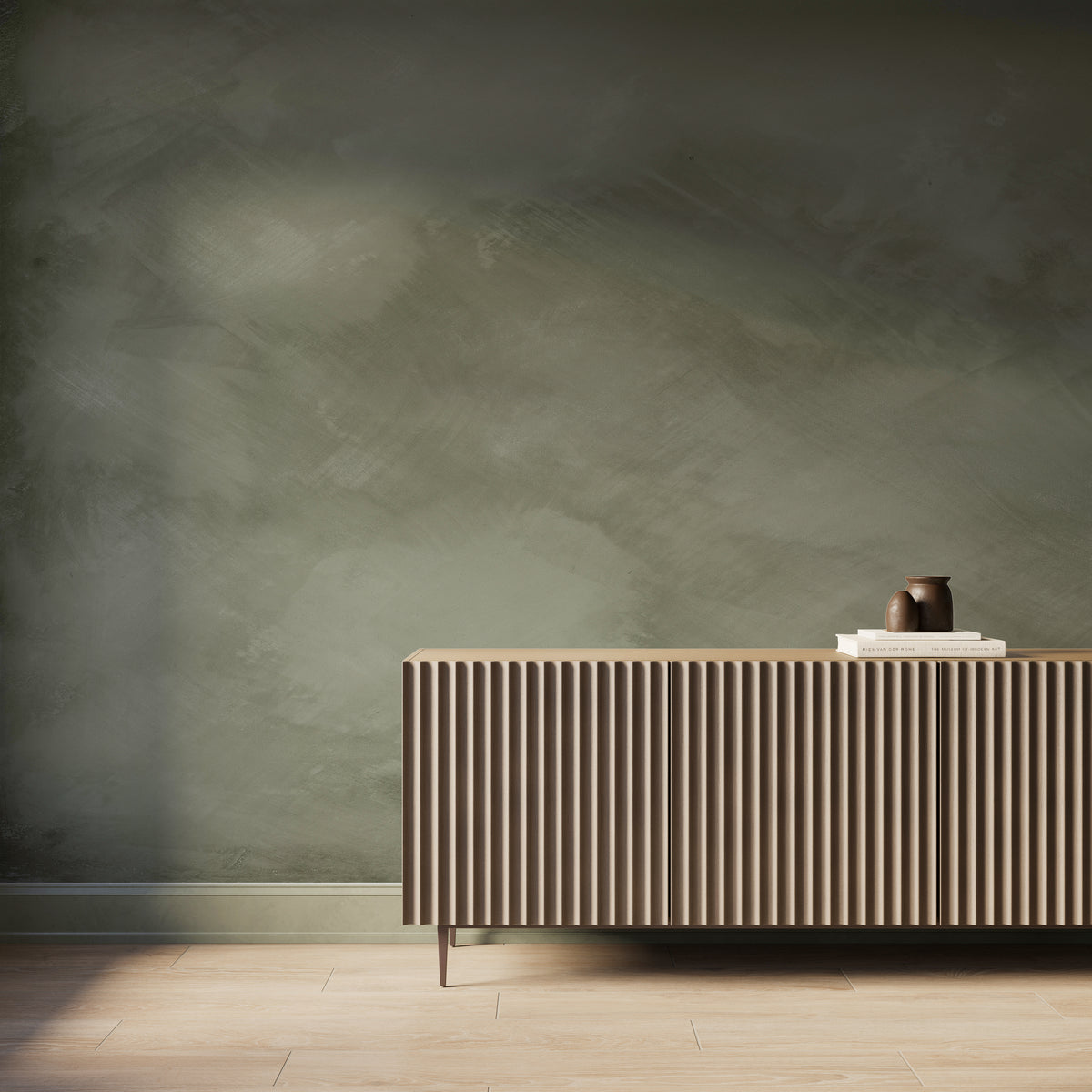 Gallery-scale olive green abstract limewash-look wallpaper mural with soft tonal texture, styled behind a modern fluted wood console.