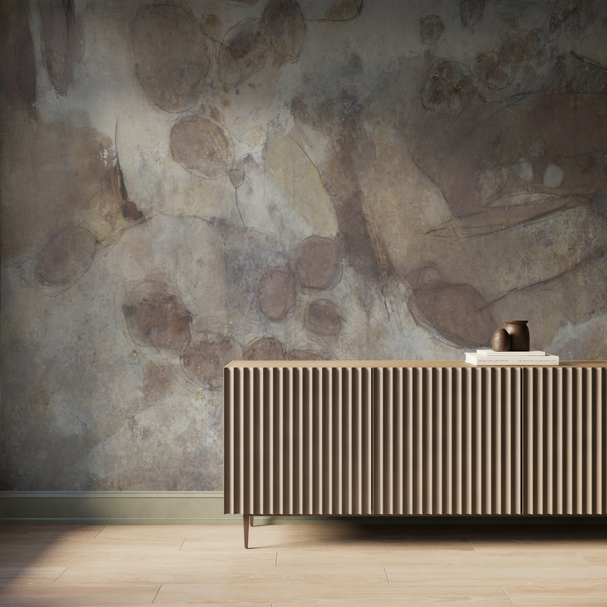 Interior scene featuring the Skyveil Mural in Mistfall II with layered light beige and rusty brown abstract plaster-like textures, styled behind a fluted wood console cabinet with light wood flooring and soft natural light across the wall.