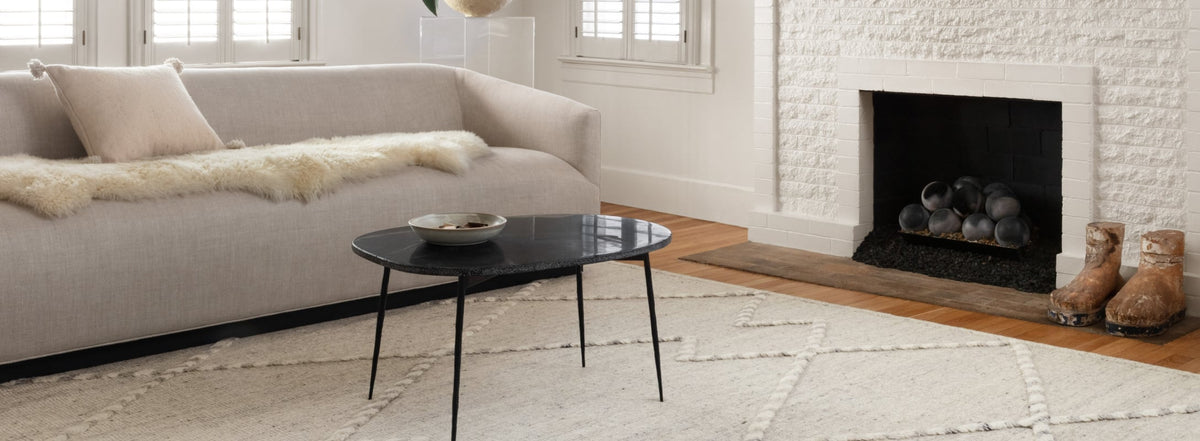 Contemporary white area rug with textured geometric patterns, enhancing a cozy living room featuring a soft sofa and a modern fireplace