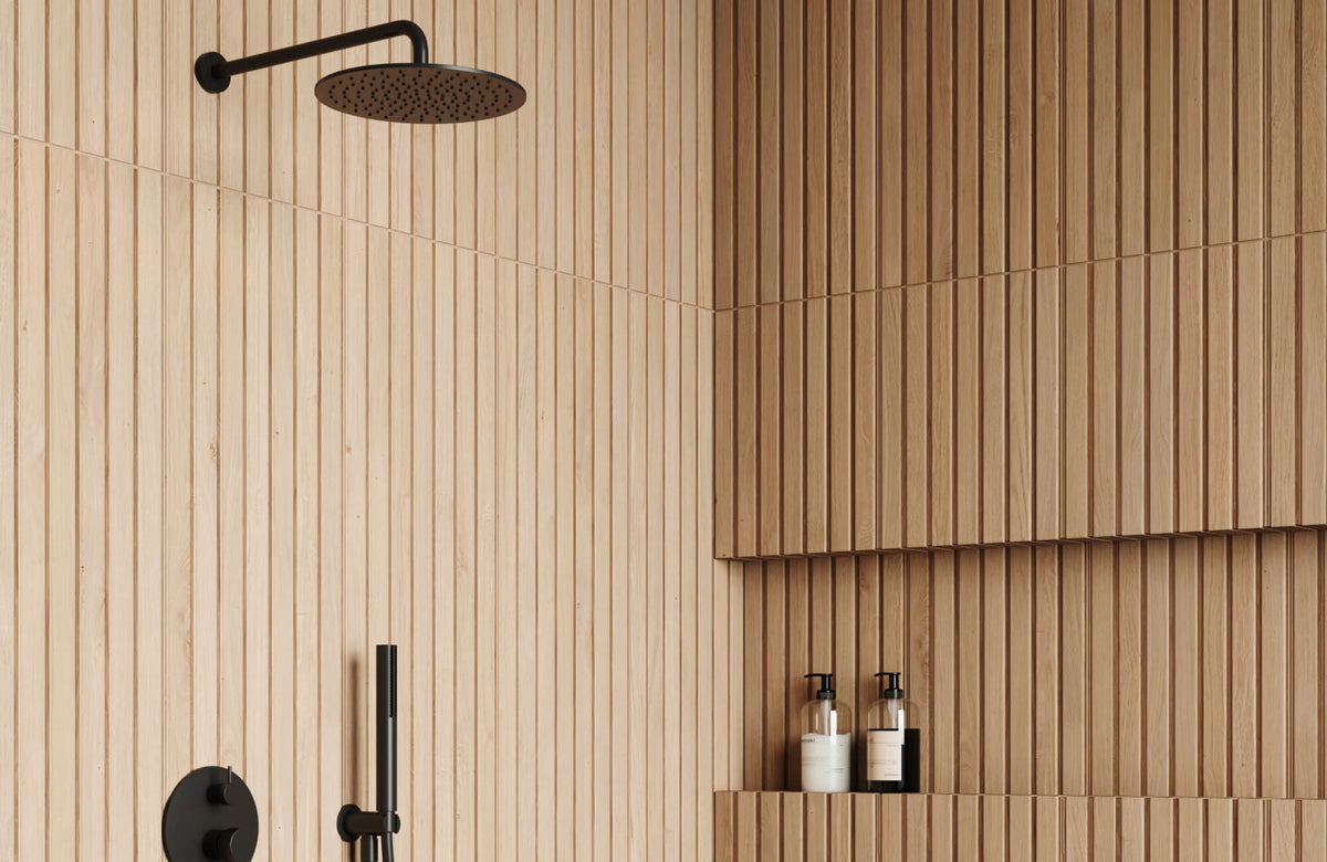 Wood-look porcelain tiles in a vertical layout wrap the shower walls, bringing realistic grain detail, warm natural tones, and lasting durability to a moisture-prone space.