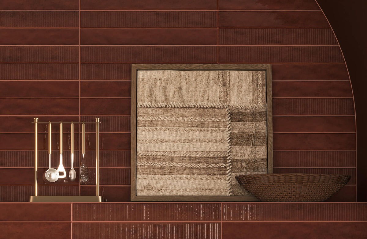 Framed textile wall art with a warm wood frame placed against rich terracotta tile, showing how a darker, earthy frame color blends with the background to create a cohesive and grounded visual effect.