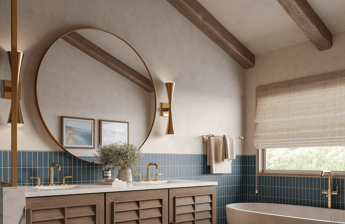 Shutter-style double sink vanity with gold fixtures, a large round mirror, sculptural sconces, and blue vertical wall tiles.