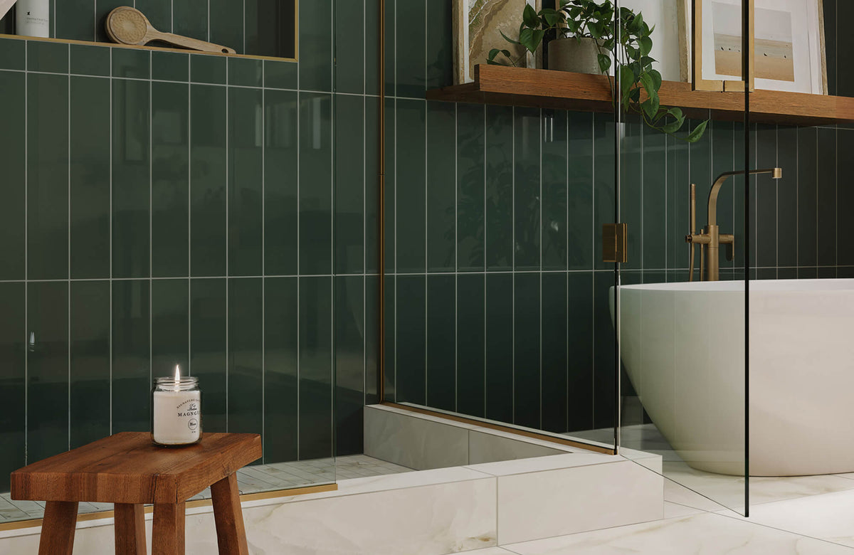 Modern bathroom with deep green tiled shower, glass enclosure, freestanding tub, and warm wood accents for contrast.