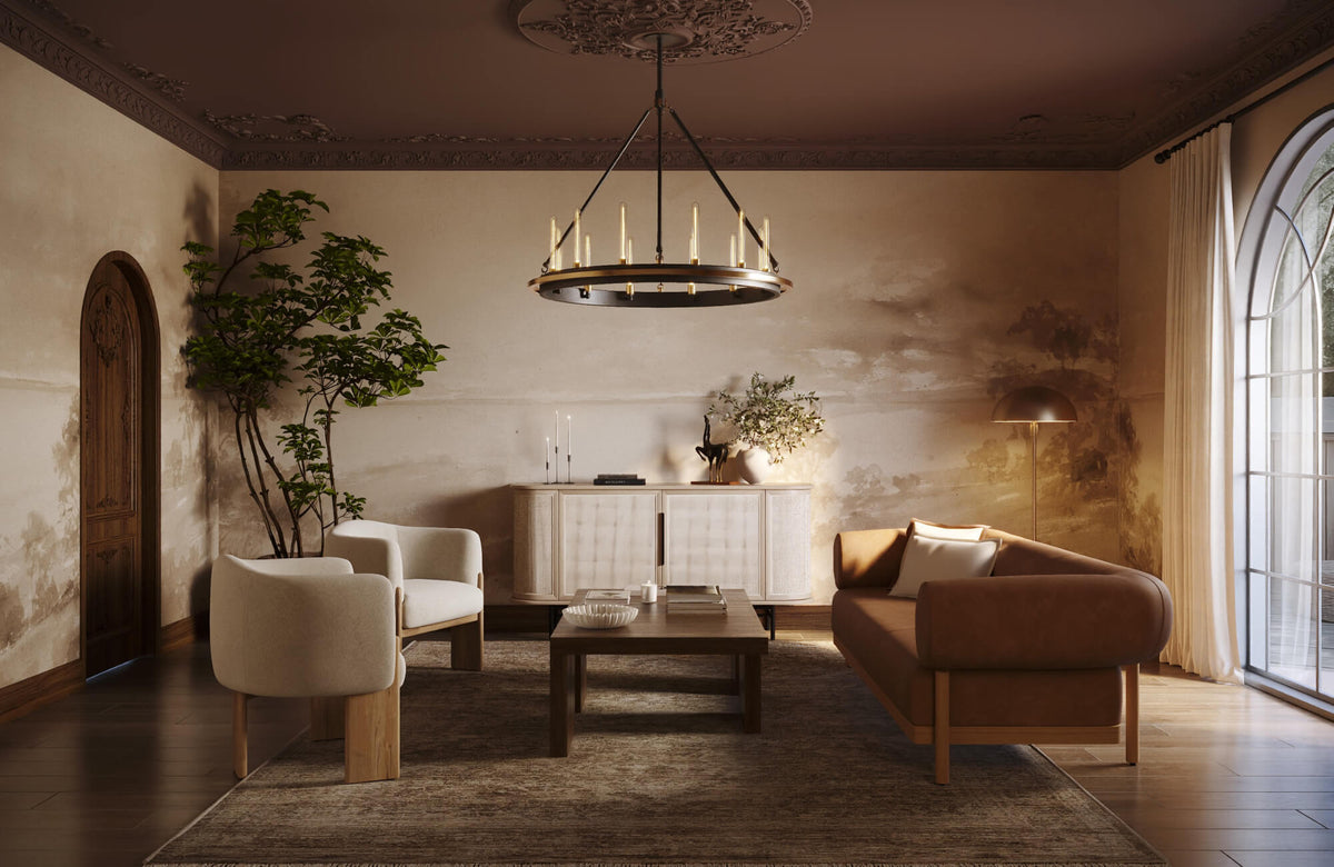 Warm living room with a centered coffee table arrangement, white armchairs, a brown sofa, layered rug, wall mural, and sculptural chandelier.