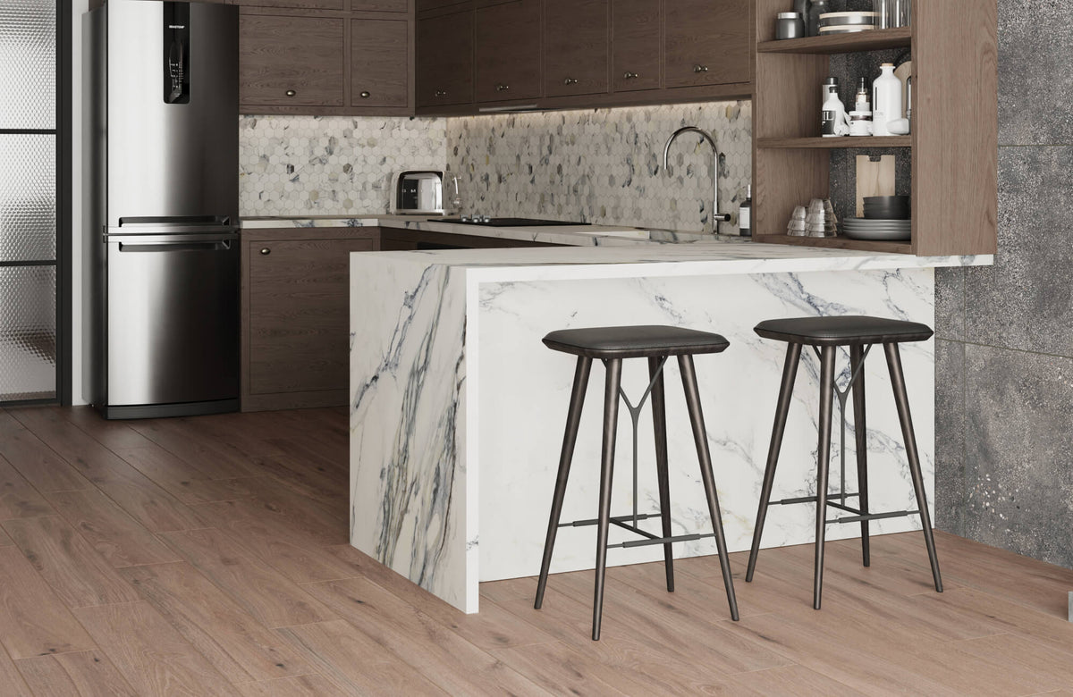 Modern kitchen with dark wood cabinetry, marble-look island, hexagon backsplash tile, stainless steel refrigerator, and warm wood look tile flooring.