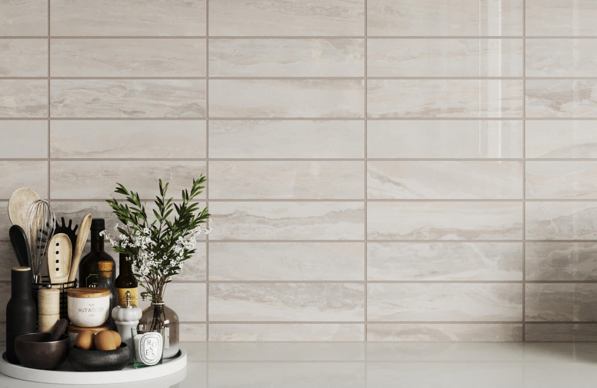 Light beige subway tile backsplash with subtle stone-like variation, arranged in a horizontal stacked layout with thin, evenly spaced light gray grout lines in a smooth, uniform finish typical of epoxy grout.