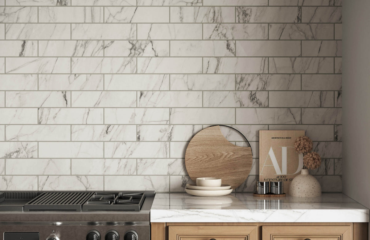 White marble subway tiles with subtle gray veining add elegance to a kitchen backsplash, complemented by a wooden countertop and decor.