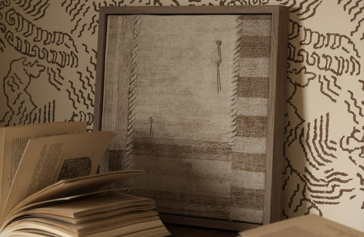 Neutral wall art with brown tones placed on patterned wallpaper, styled with books, highlighting decor that remains visible in low-light interiors.