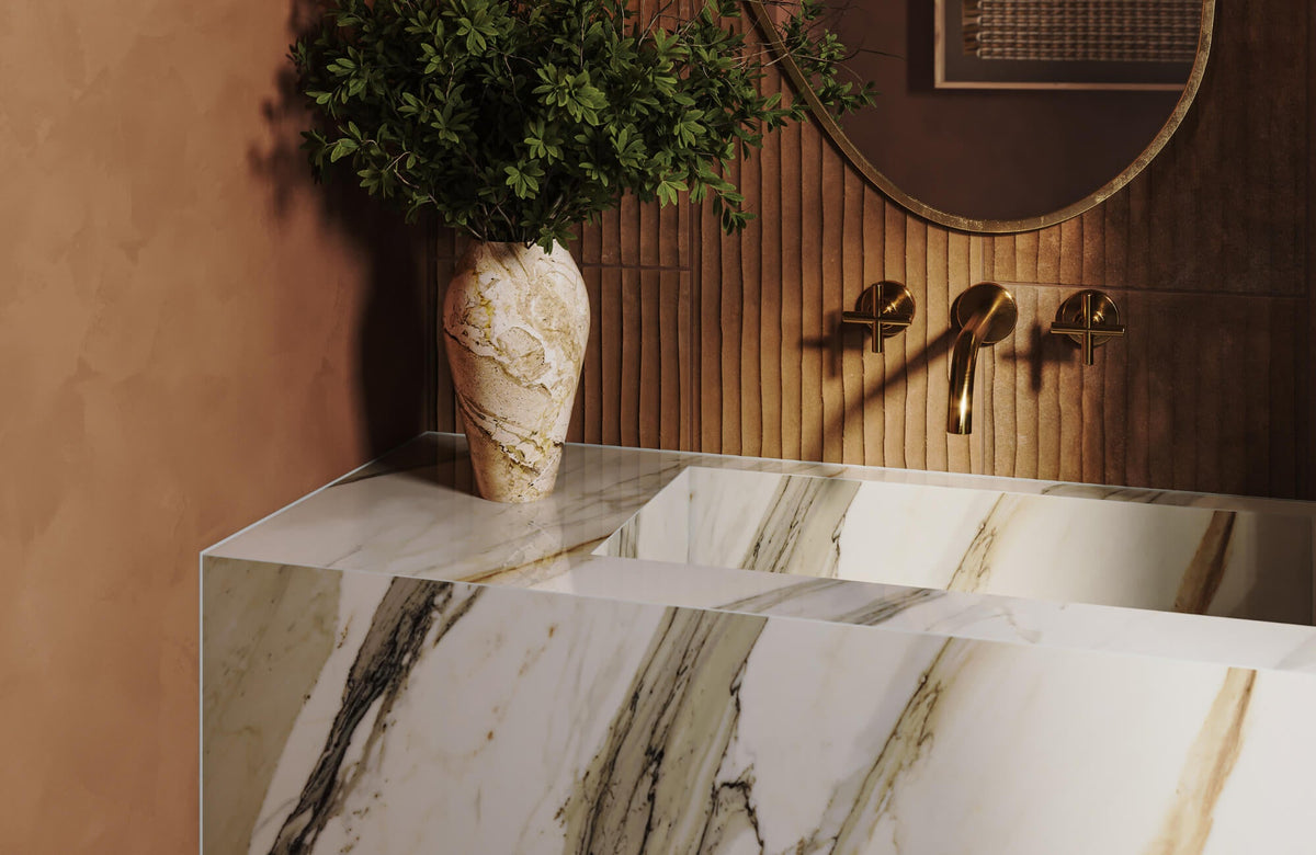Modern marble sink and vanity with gold fixtures against warm wall paneling, highlighting elegant marble design for floor and surfaces.