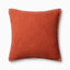 A warm dark orange pillow with woven texture, white whipstitched flange edges, and an antique bronze zipper concealed by a tailored flap, finished with a light, breathable cotton feel.
