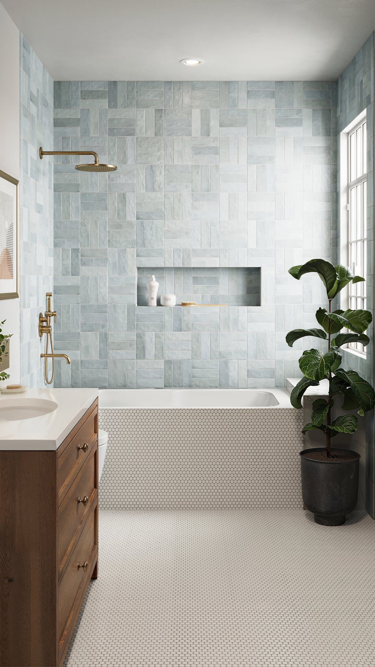 This bathroom features blue wall tiles,  brass fixtures for warmth, and a clean white hexagonal mosaic floor for a modern yet timeless design.