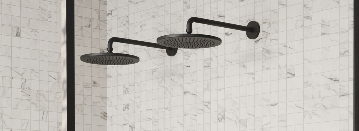 Modern bathroom with dual black shower heads against a backdrop of white marble mosaic tiles