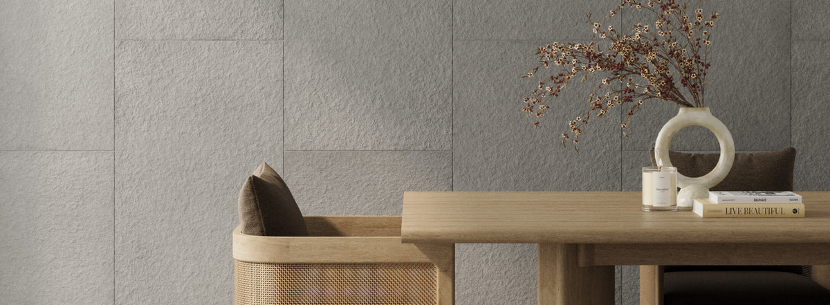 Sophisticated setting with textured stone-look wall tiles, a wooden table adorned with a modern vase and decorative books