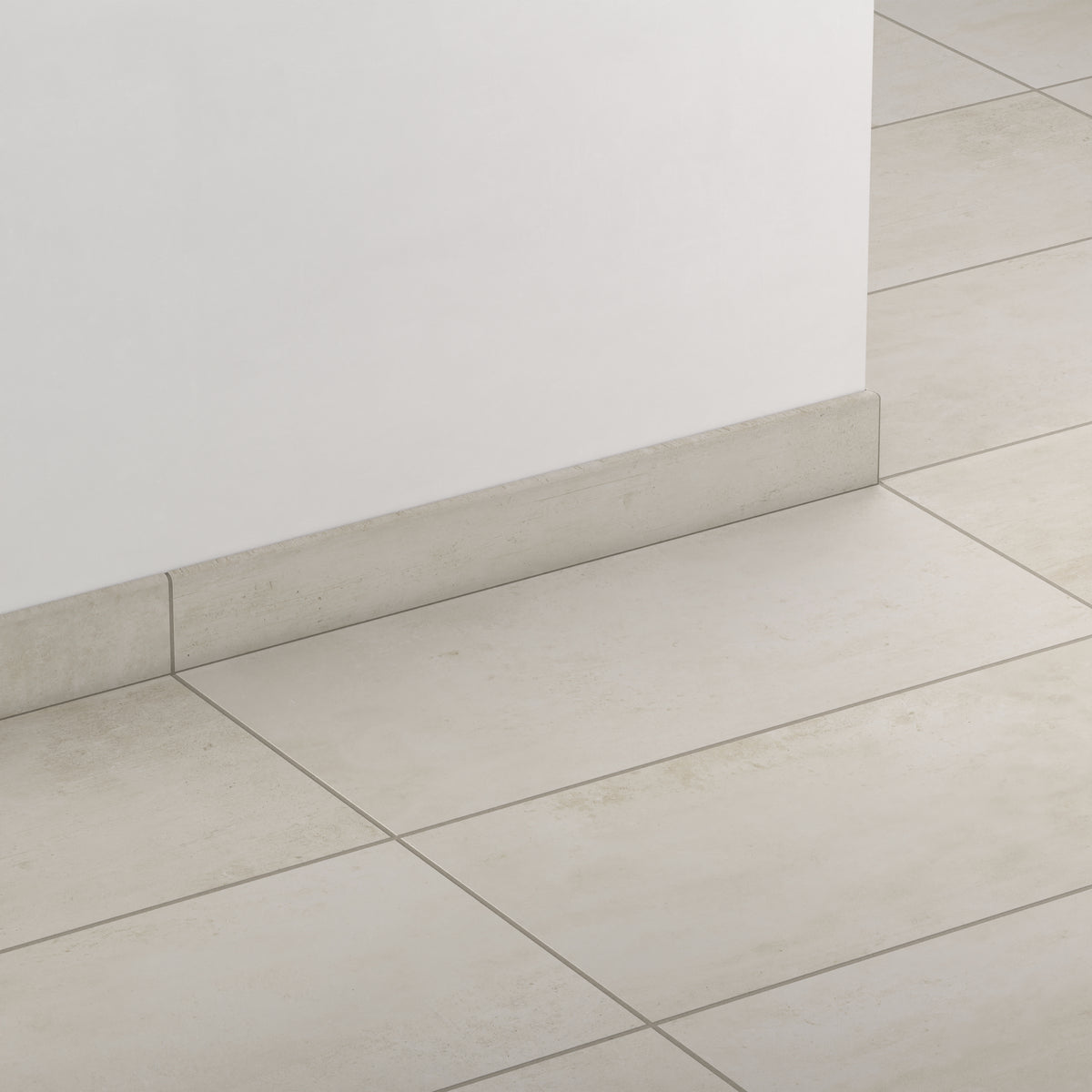 Floor detail showcasing Ramsey Chalk 3x24 matte bullnose tiles as sleek baseboards, offering a seamless transition for elegant interiors