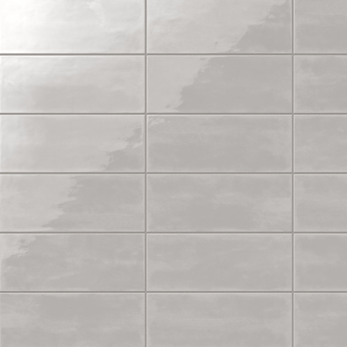 Glossy 4x10-inch ceramic subway tiles in a light gray hue, arranged in a clean and uniform grid pattern
