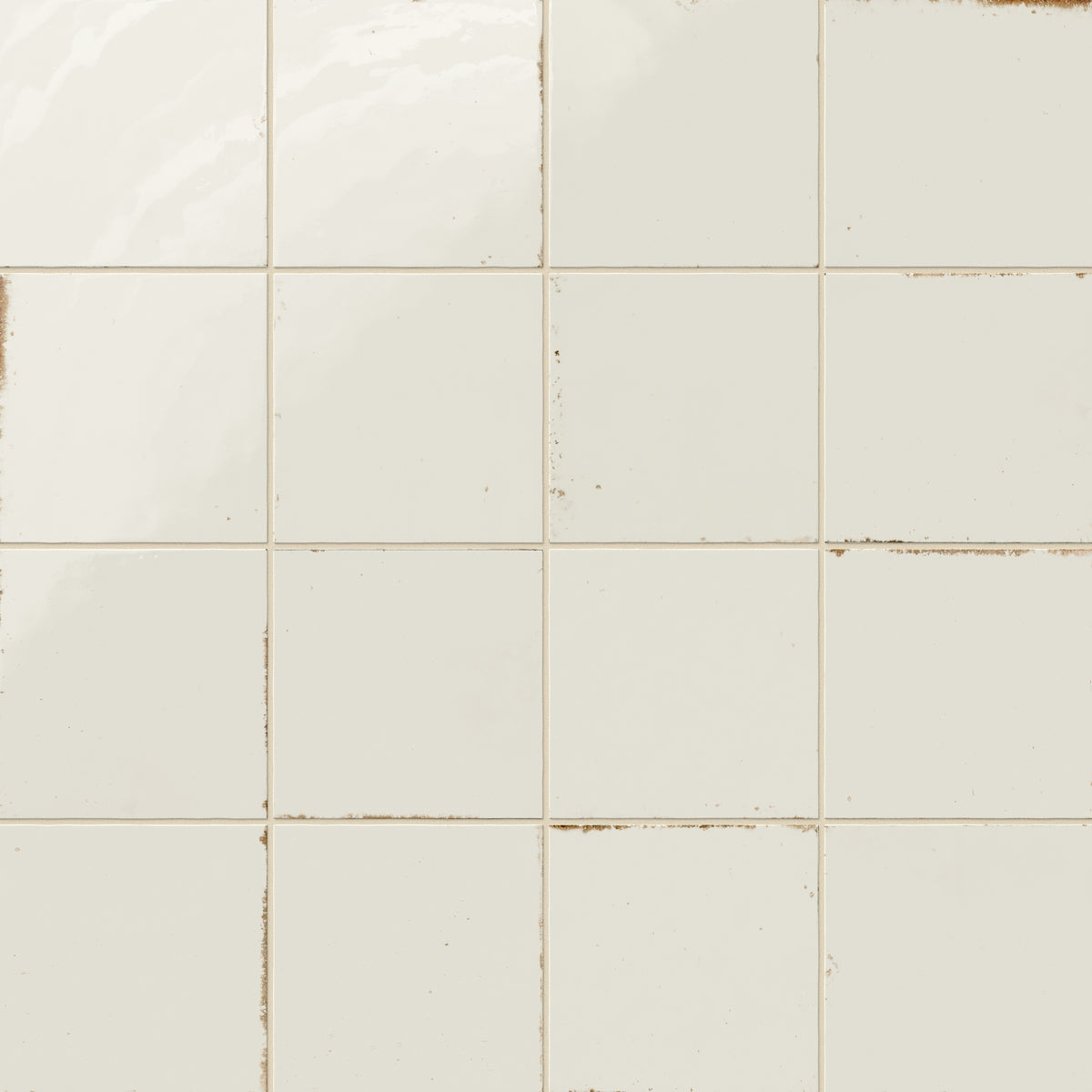 Soft white porcelain tiles featuring a glazed finish with worn accents that create a vintage, timeworn effect.