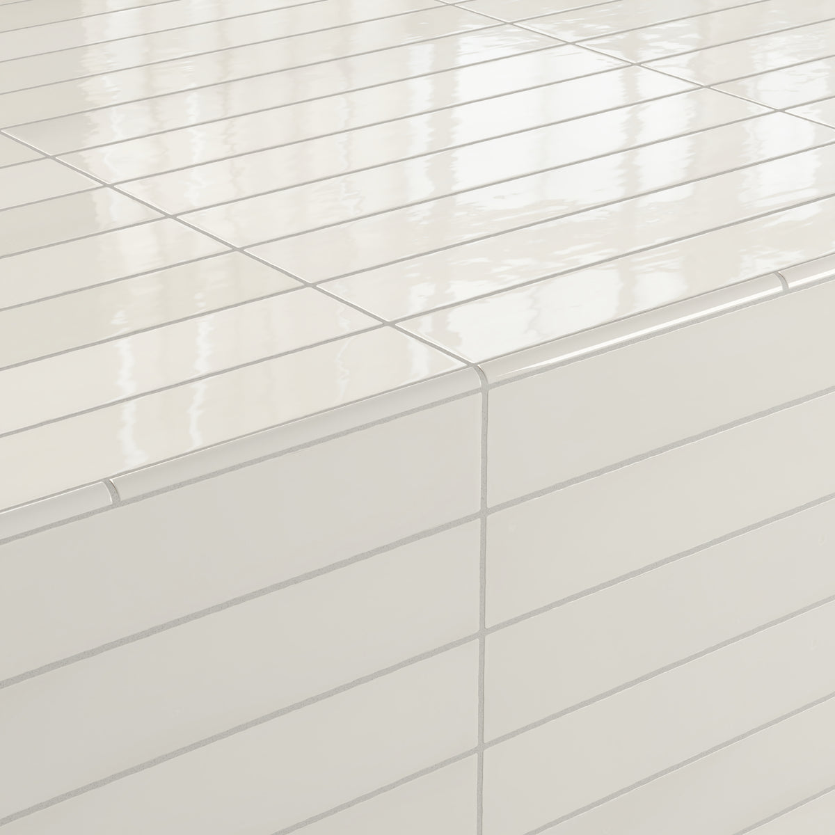 White glossy Maisie quarter-round tiles installed on a countertop corner, showcasing seamless edges and a smooth finish